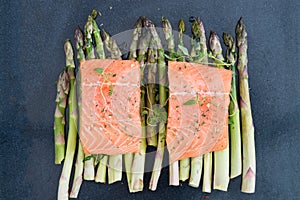 Raw uncooked salmon and asparagus on baking tray