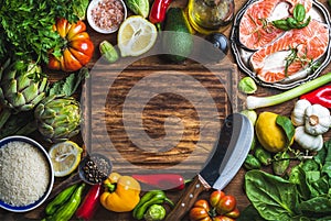 Raw uncooked salmon fish with vegetables, rice, herbs, spices and wine on chopping board over rustic wooden background