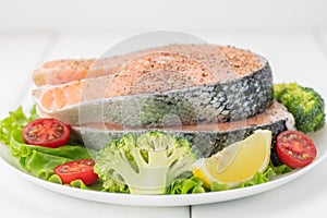 Raw uncooked salmon steak with fresh vegetables