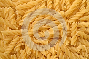 Raw uncooked spiral pasta background