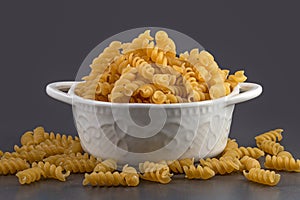 Raw uncooked spiral pasta in bowl. Raw pasta, macaroni, Dry spiral pasta. Delicious pasta or spiral noodles