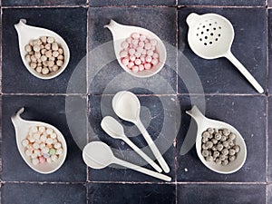 Raw, uncooked tapioca pearls on gray tile background