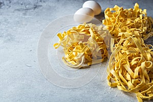 Raw uncooked traditional Italian pasta on a gray background. Copy space