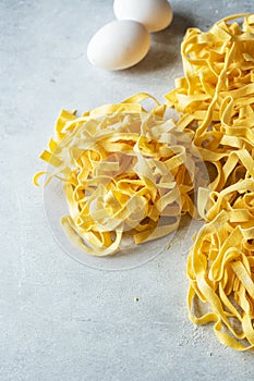 Raw uncooked traditional Italian pasta on a gray background. Copy space