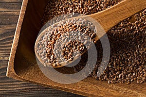 Raw, unprocessed linseed or flax seed in wooden scoop