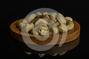 Raw unsalted cashew isolated on black glass