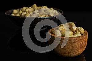 Raw unsalted cashew isolated on black glass