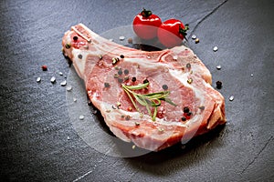 Raw veal cutlet at black slate plate
