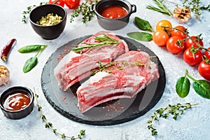 Raw veal steak on the bone, on a black slate plate.