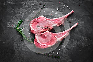 raw veal steak on the bone on the dark stone photo