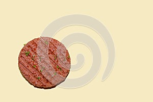 Raw vegan plant-based meat burger on a yellow background