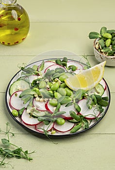 Raw vegan salad with radish, cucumber, green pea, sunflower and soy sprouts, edamame and flax seeds. Vegetarian healthy diet food