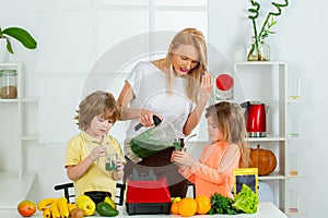 Raw, vegan, vegetarian, alkaline food concept. Mother and children eating fruits and drinking smoothie, mothers day