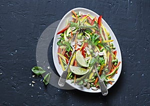 Raw vegetables Pad Thai salad on dark background, top view. Vegetarian healthy food.