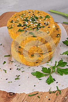 Raw veggie burger with chickpeas, vegetables and parsley leaves on kitchen countertop