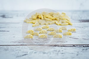 Raw vehicle-shaped pasta in pile on wooden table