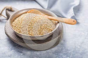 Raw  white  quinoa seeds lat. Chenopodium quinoa on  plate with wooden spoon
