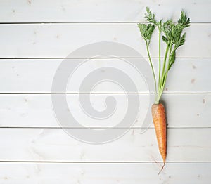 Raw whole carrot on wooden surface table