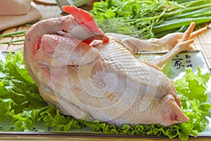 Raw whole chicken in a plate
