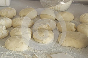 Raw yeast dough for baking rolls, pies or bread. On the background of the kitchen table flour, home baking concept