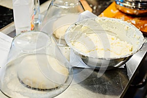 Raw yeast dough under glass bowl