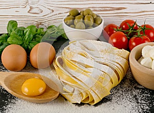 Raw yellow italian pasta pappardelle, fettuccine or tagliatelle