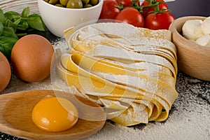 Raw yellow italian pasta pappardelle, fettuccine or tagliatelle