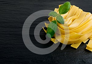 Raw yellow italian pasta pappardelle, fettuccine or tagliatelle