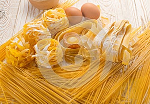 Raw yellow italian pasta pappardelle, fettuccine or tagliatelle