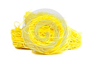 Raw yellow italian pasta pappardelle, fettuccine or tagliatelle close up. Homemade dry ribbon noodles, long rolled