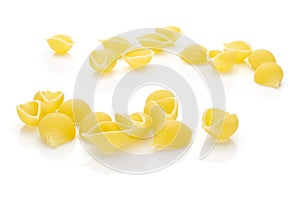 Raw yellow pasta conchiglie isolated on white