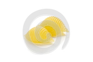 Raw yellow pasta conchiglie isolated on white