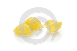 Raw yellow pasta conchiglie isolated on white