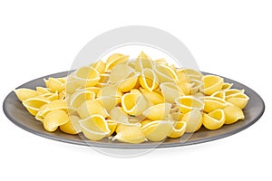 Raw yellow pasta conchiglie isolated on white