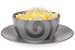 Raw yellow pasta conchiglie isolated on white