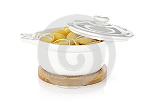 Raw yellow pasta conchiglie isolated on white