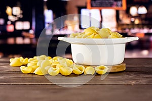 Raw yellow pasta conchiglie with restaurant