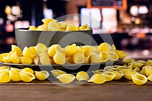 Raw yellow pasta conchiglie with restaurant