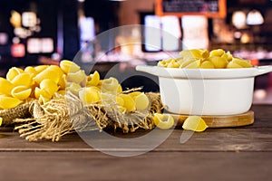 Raw yellow pasta conchiglie with restaurant