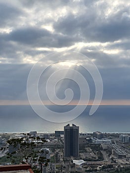 Ray of light through the clowds on the town and calm blue sea