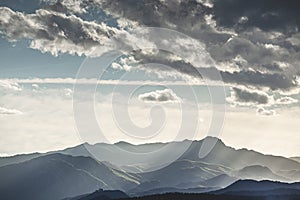 The rays through the mountains filtered by the clouds