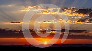 Rays of light fan out through scattered clouds creating a dramatic effect