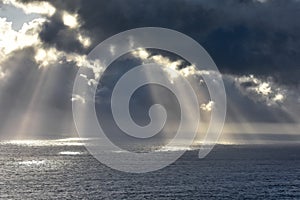 Rays of light that pass over the clouds and illuminate the sea like spotlights. Concept of nature and sea. Galicia, Spain