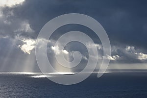 Rays of light that pass over the clouds and illuminate the sea like spotlights. Concept of nature and sea. Galicia, Spain