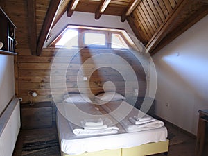 Rays of light penetrate the cozy wooden bedroom