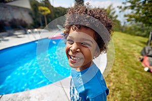 Rays of Poolside Joy: Afro-American Boy\'s Infectious Laughter Lights Up the Scene