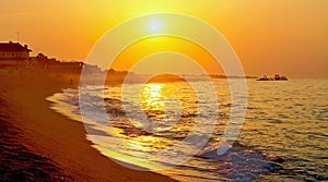 The rays of the rising sun over the Mediterranean Sea with a muddy background in Malgrat de Mar, Spain.