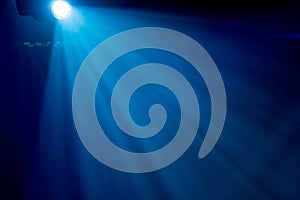 The rays of searchlights in smoke on stage during a performance