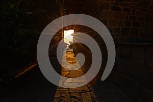 The rays of the setting sun shine through the narrow long arch of the building of the monastery on Mount Athos