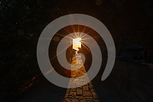 The rays of the setting sun shine through the narrow long arch of the building of the monastery on Mount Athos